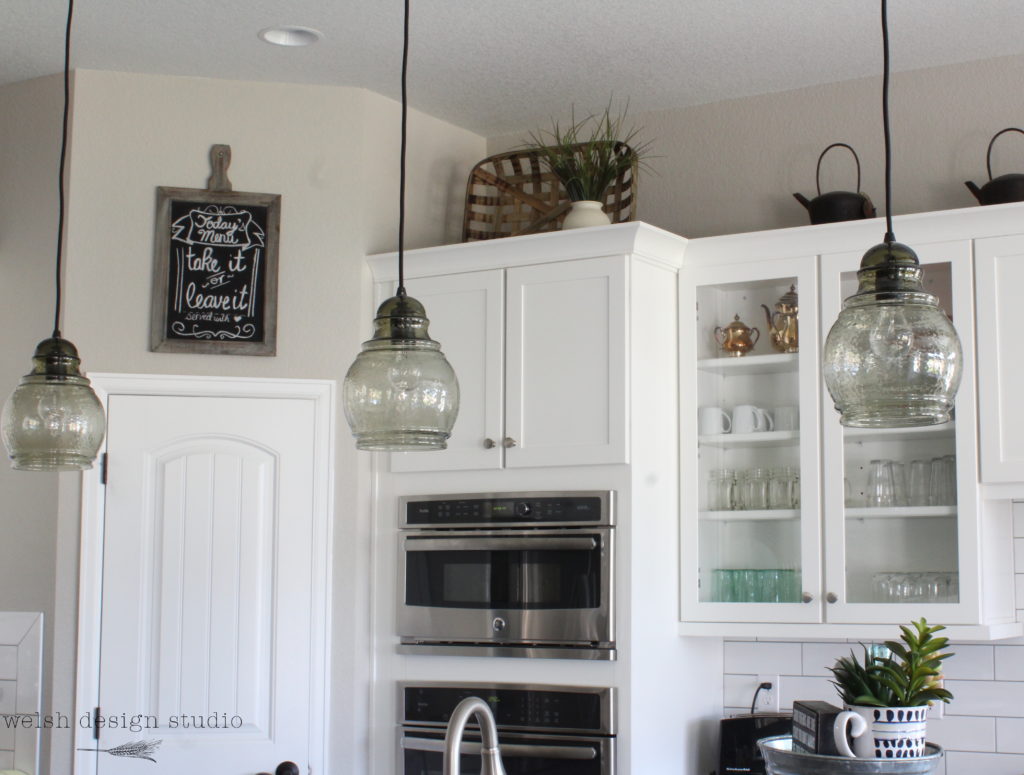 white kitchen with glass pendant lights