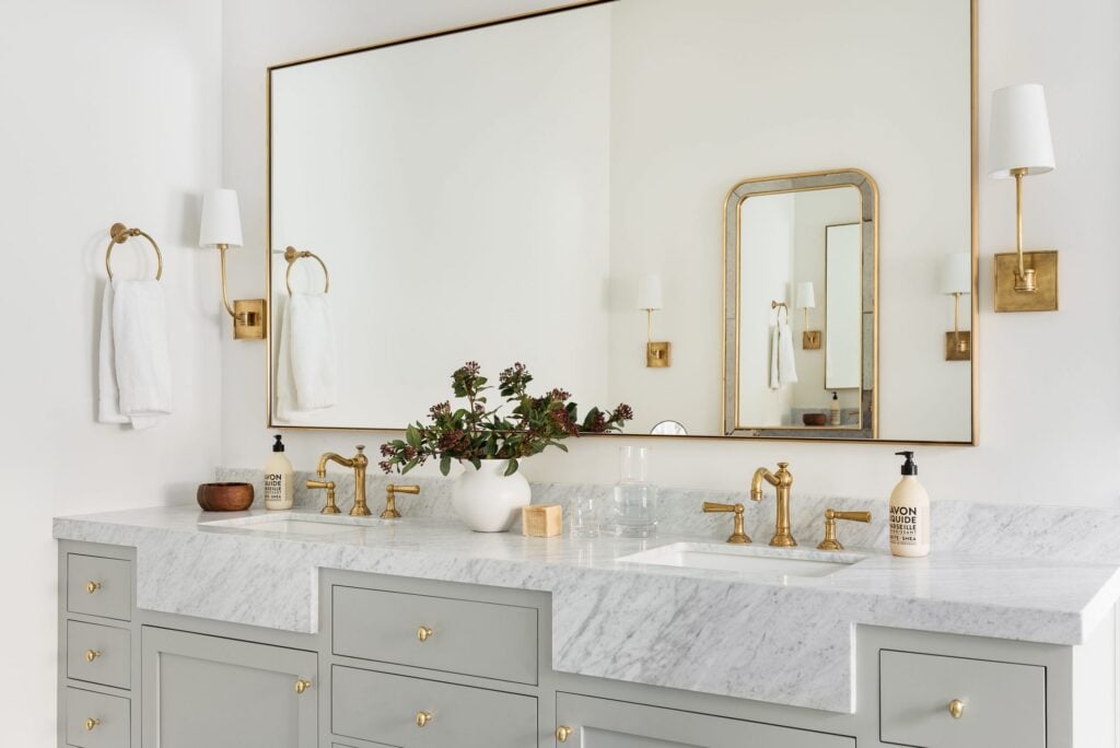 bathroom with gray-green vanity and marble countertops